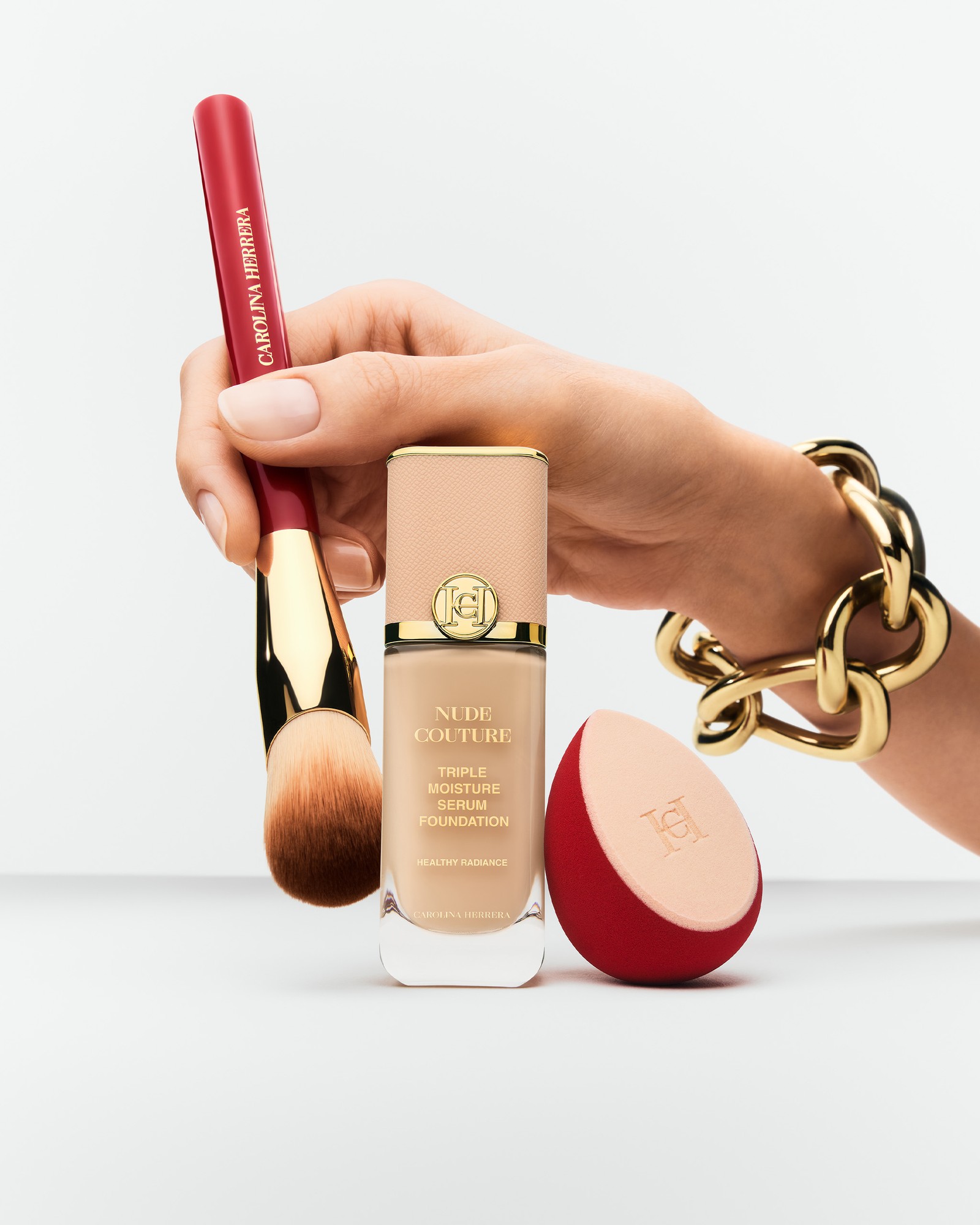 studio bakuza fond de teint nude couture carolina herrera hand holding a make up brush and sponge